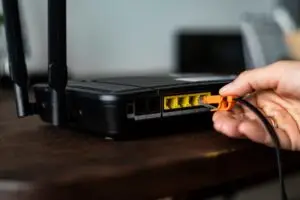 Man Plugging Ethernet Cable Wireless Router 53876 139544